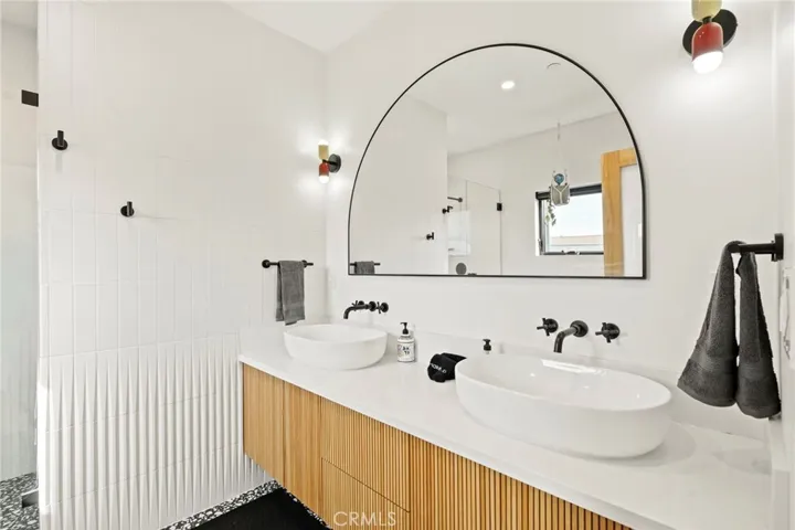 Ensuite bathroom with solid wood floating dual vanity with wall-mounted faucets