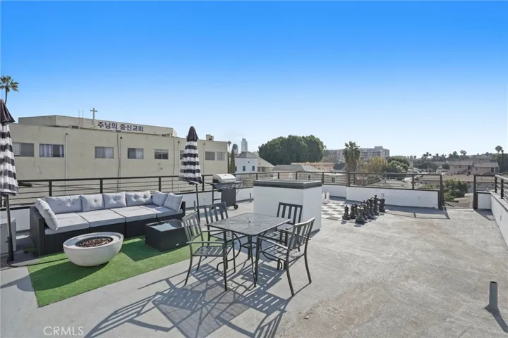Roof deck with fire pit, al fresco dining, seating area, barbecue grill, and 360 degree panoramic views from DTLA to Griffith Observatory to the Hollywood sign
