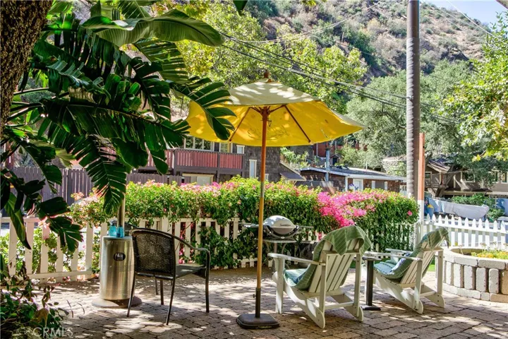 Private front courtyard with bougainvillea in the front, trees on the side.