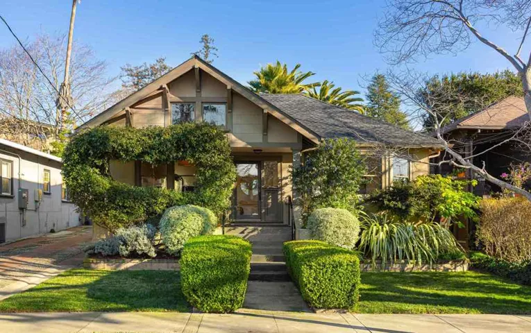 View of front facade with roof with shingles and a front lawn