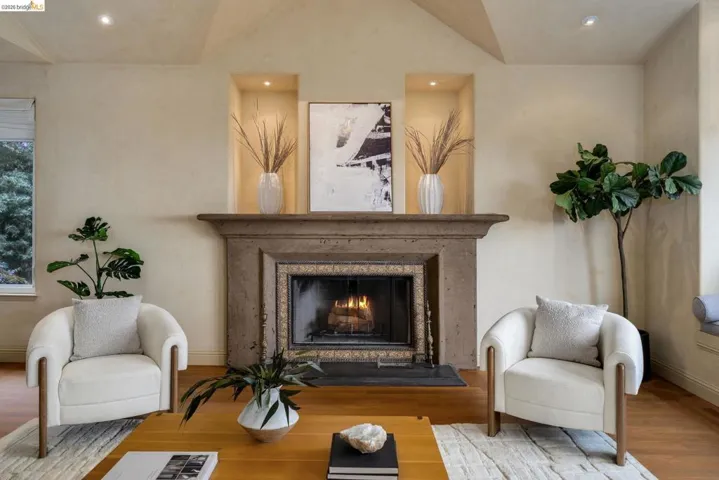 Living area with a premium fireplace, wood finished floors, and recessed lighting