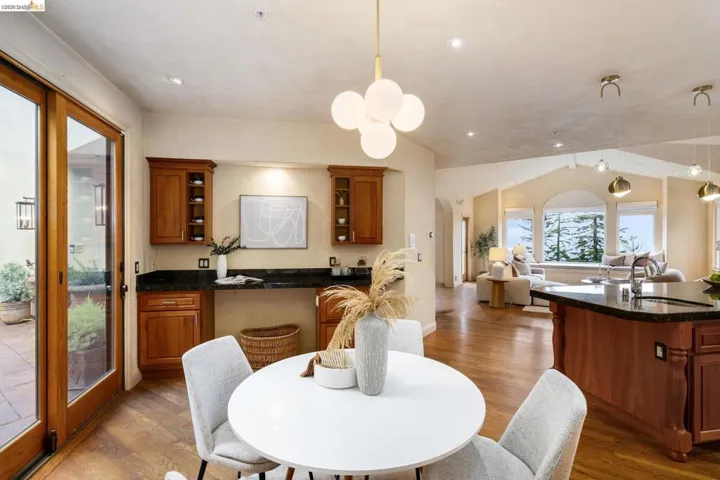 Dining area with light wood finished floors, arched walkways, and lofted ceiling