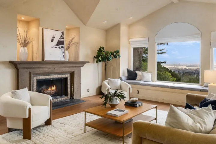 Living area featuring wood finished floors, a warm lit fireplace, recessed lighting, and high vaulted ceiling