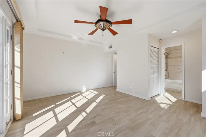 Main bedroom with french doors, ceiling fan, trey ceiling, two closets