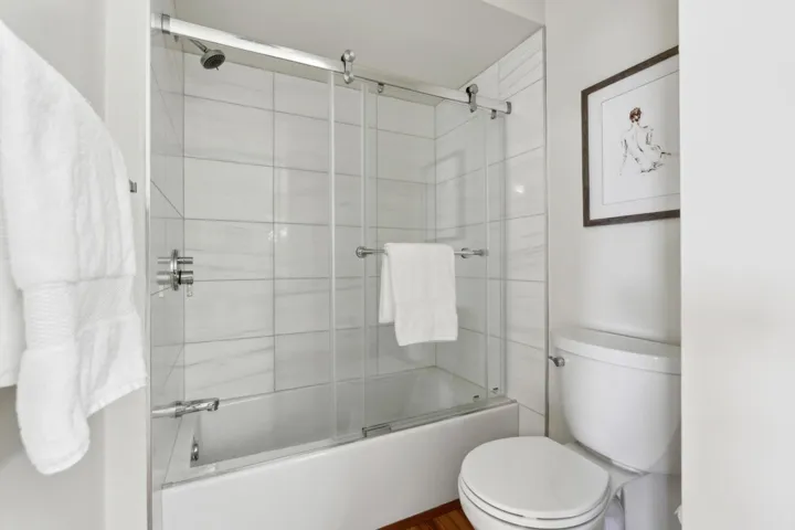 Full bath with shower / bath combination with glass door and toilet