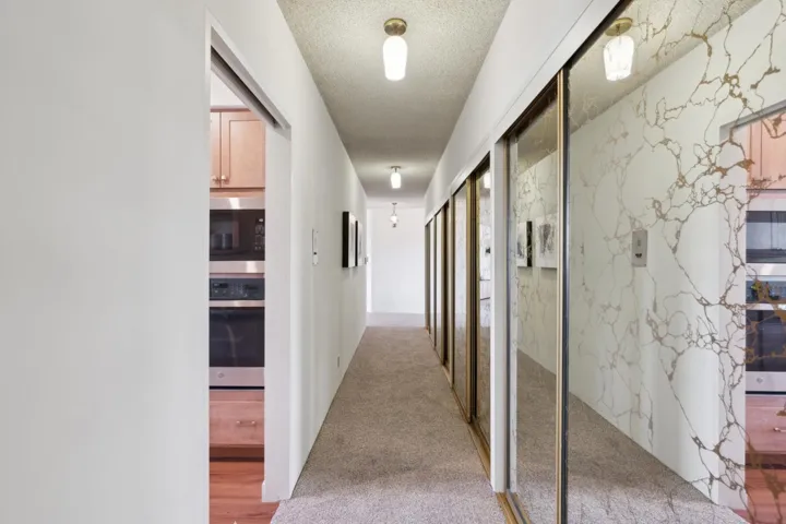 Hall with light carpet and a textured ceiling