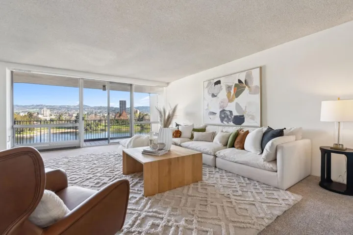Living room with carpet flooring, a wall of windows, a textured ceiling, and a mountain view