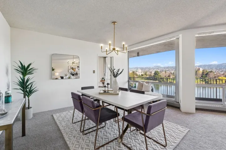Dining space with light carpet, a textured ceiling, and a chandelier
