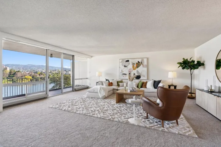 Living room with expansive windows, carpet flooring, a textured ceiling, and a water and mountain view