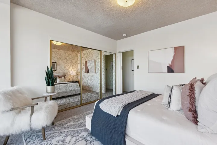 Carpeted bedroom featuring a textured ceiling and a closet
