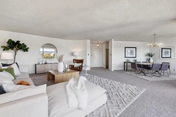Living area with carpet, a chandelier, and a textured ceiling