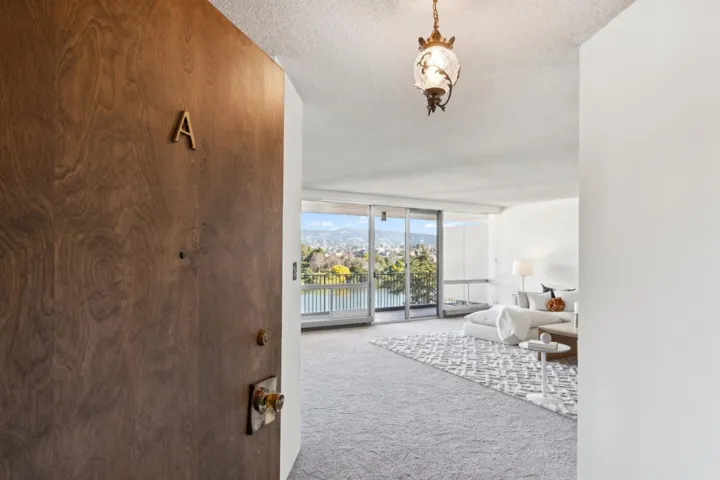 Hallway featuring floor to ceiling windows, carpet flooring, a textured ceiling, and a water view
