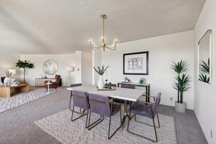Dining room with light carpet, a chandelier, and a textured ceiling