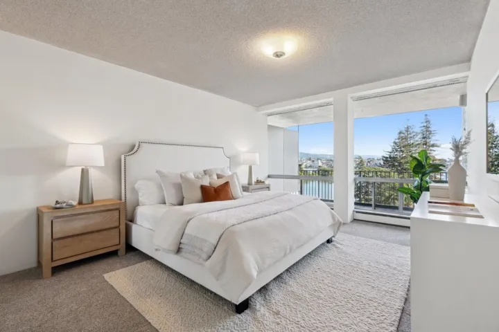 Bedroom featuring carpet floors, a textured ceiling, a water view, a baseboard heating unit, and expansive windows