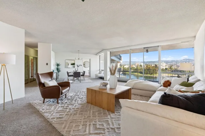 Living room with a textured ceiling, carpet, and a water view