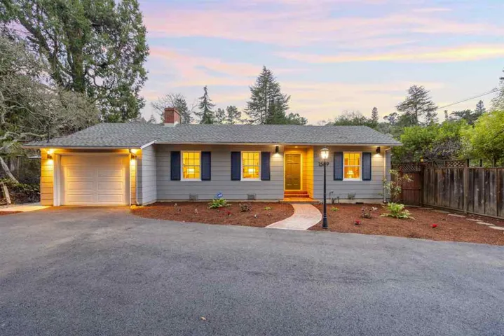 Ranch-style home with a garage, driveway, and a chimney