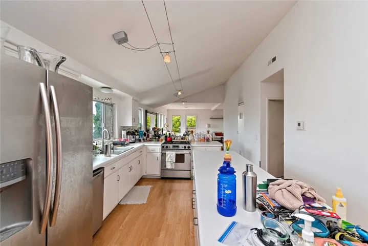 Top floor open kitchen with gas range, dishwasher, refrigerator and stackable washer and dryer.