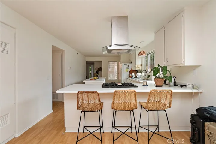 Open concept kitchen with gas range, dishwasher, refrigerator and stackable washer/dryer