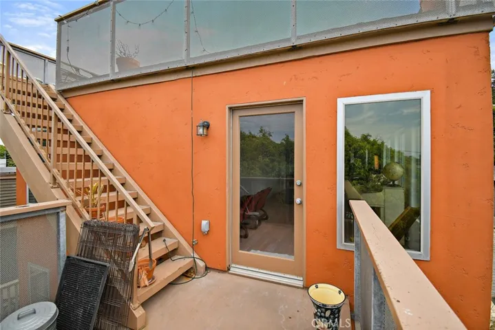 Top floor balcony with stairs leading to rooftop deck.