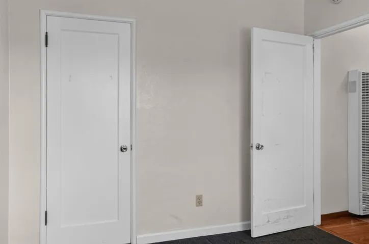 Unfurnished bedroom featuring a heating unit and baseboards