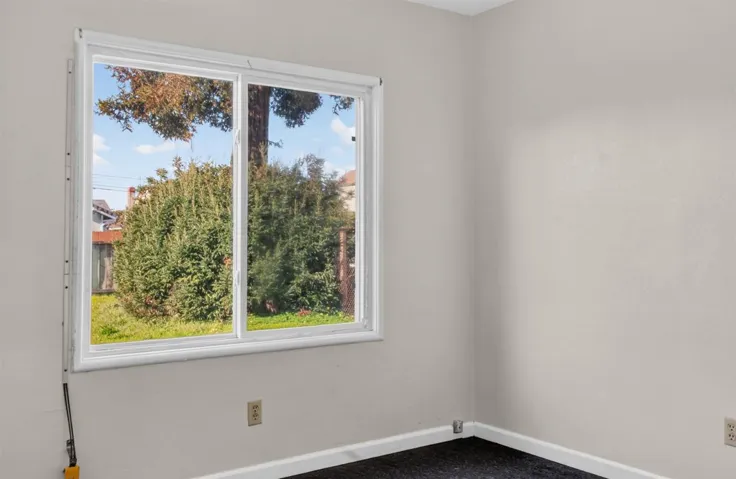 Carpeted spare room featuring baseboards