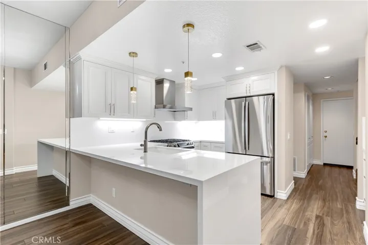 The quartz countertop feature a bartop eating area as well as a waterfall edge.