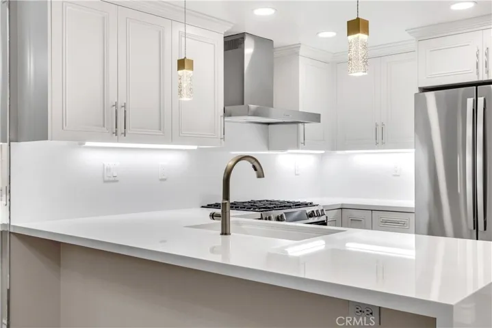 The chef's kitchen features brand new countertops, backsplash, custom cabinetry, stainless steel appliances, pendant lights and more.