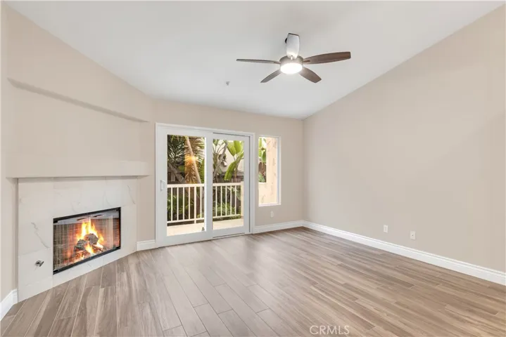 The primary bedroom has a gas fireplace, balcony, vaulted ceilings and a ceiling fan.