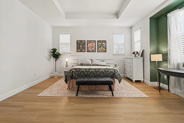 Bedroom featuring light wood-type flooring and a tray ceiling