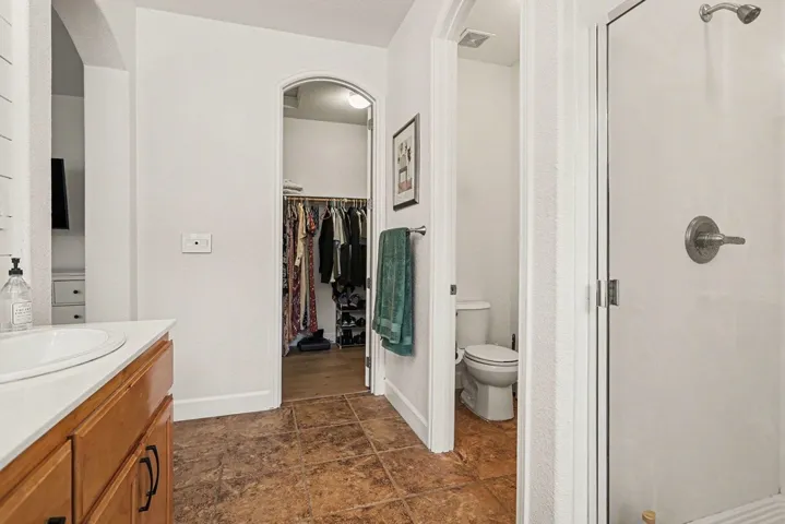 Bathroom featuring vanity, a walk in closet, and a shower stall