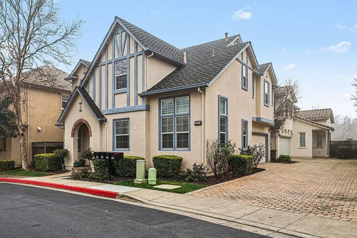 Tudor home with stucco siding and decorative driveway