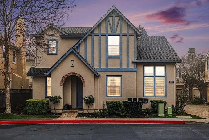 English style home with stucco siding and roof with shingles