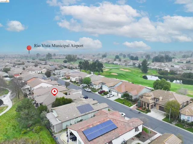 Aerial view of property's location with nearby suburban area and a golf course