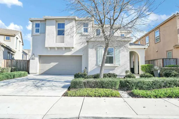 Traditional-style home with stucco siding, driveway, and a garage