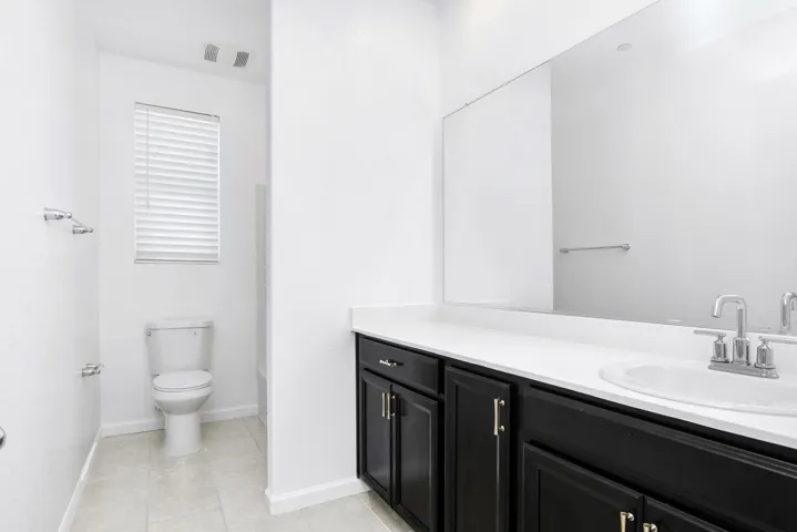 Full bath featuring vanity and light tile patterned flooring