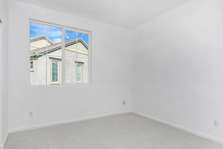 Spare room featuring baseboards and light colored carpet
