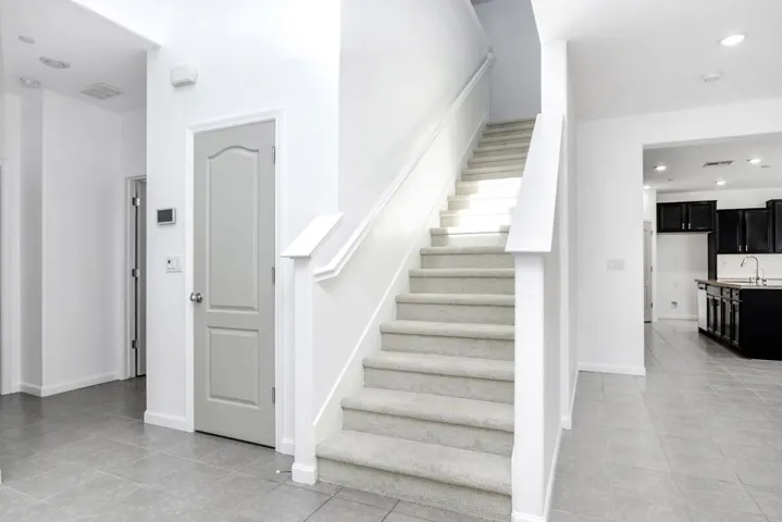 Stairway featuring recessed lighting and tile patterned floors