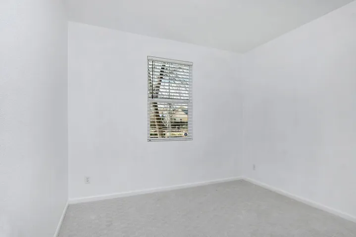Carpeted spare room featuring baseboards