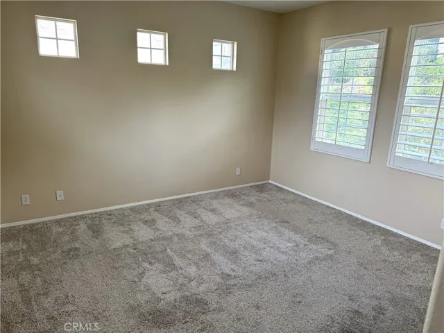 Primary Bedroom With Two Large Windows On Each Side with four Small Windows Adjacent.   Plantation Shutters.