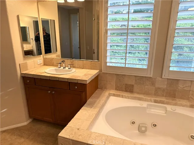 Primary Bath Vanity #2. View of Back Yard Thru Plantation Shutters.