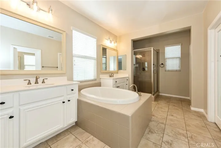 Luxurious master bath w/dual vanities, a separate soaking tub, and a walk-in shower