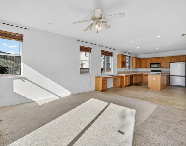 Unfurnished living room with light colored carpet, recessed lighting, and a ceiling fan
