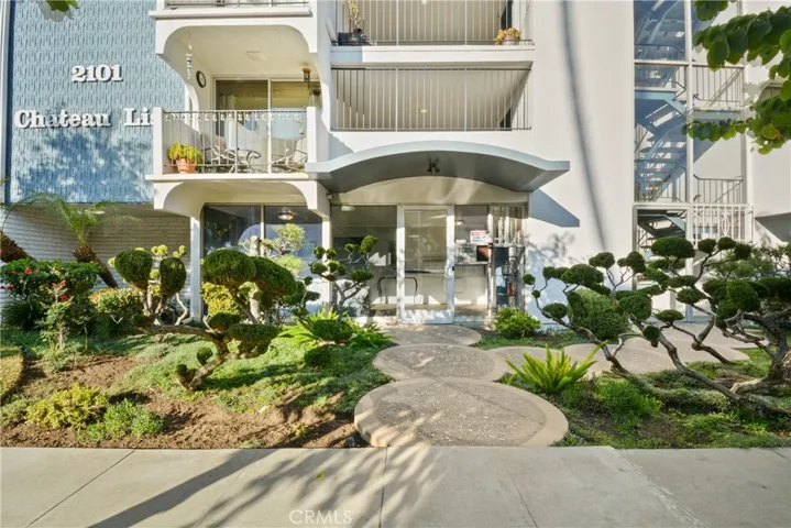 Welcoming main entrance of Chateau Lisa featuring beautifully manicured mid-century coastal landscaping