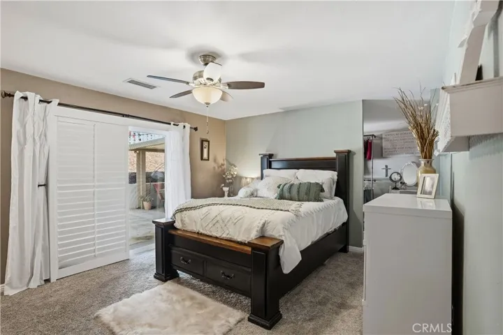 Primary bedroom has plantation shutters and access to the spa outside.