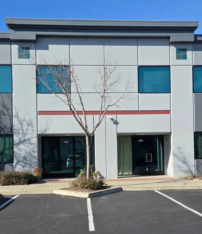 View of building exterior featuring uncovered parking