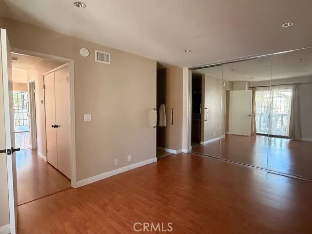 Master bedroom with wall to wall mirror closet