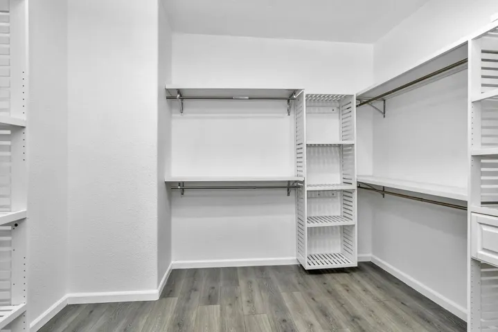 Walk in closet with light wood-type flooring