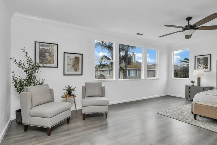 Living area with ceiling fan, ornamental molding, and light wood finished floors