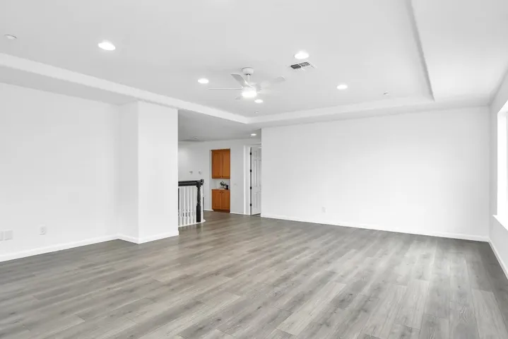 Unfurnished room with recessed lighting, a raised ceiling, light wood-type flooring, and ceiling fan