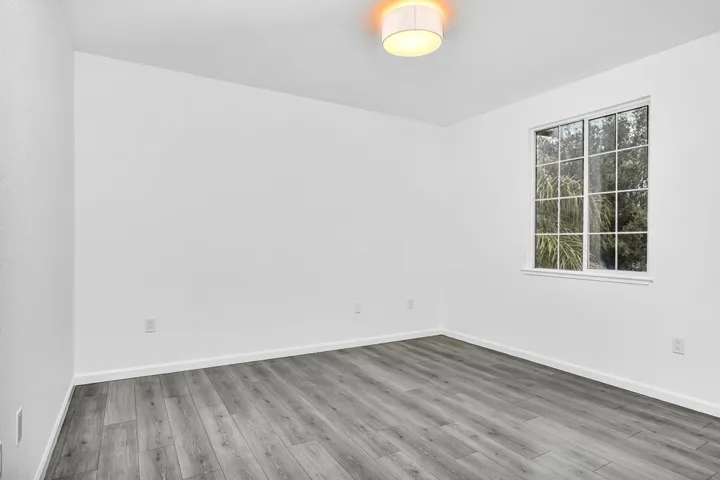 Empty room with baseboards and light wood-type flooring